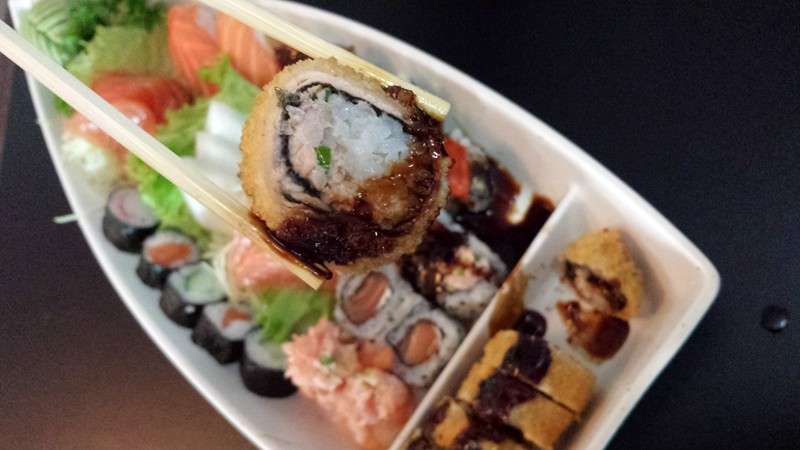 Hot rolls e uramakis numa travessa com hashi